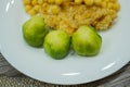 Lentils and green boiled brussels sprouts on a white plate