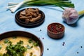 Lentils or pea soup with parsley, onions, garlic, rye bread crackers and aromatic black, red, pink, white pepper set on blue table Royalty Free Stock Photo