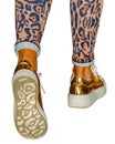 Golden sneakers and leopard prints leggings Royalty Free Stock Photo