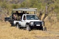 A leopard and a safari vehicle