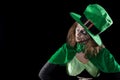 Leprechaun girl looking to copyspace, black background, concept