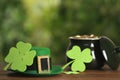 Leprechaun hat, clover leaves and pot of gold on wooden table against blurred background, space for text. St Patrick`s Day Royalty Free Stock Photo