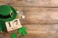 Leprechaun`s hat, block calendar and St. Patrick`s day decor on wooden background, flat lay. Space for text Royalty Free Stock Photo