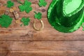 Leprechaun`s hat and St. Patrick`s day decor on wooden background, flat lay. Space for text Royalty Free Stock Photo