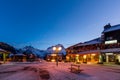 Nightlife in alpine village with traditional wooden houses, shops and restaurants Royalty Free Stock Photo