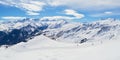 Les Sybelles ski slopes and surrounding white mountain peaks, on a sunny Winter day - panorama in the French alps Royalty Free Stock Photo