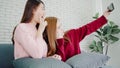 Lesbian Asian couple using smartphone selfie in living room at home, sweet couple enjoy funny moment while lying on the sofa when Royalty Free Stock Photo