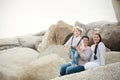 A lesbian couple with a child on the rocks at a beach Royalty Free Stock Photo