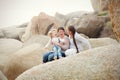 A lesbian couple with a child on the rocks at a beach Royalty Free Stock Photo