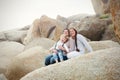 A lesbian couple with a child on the rocks at a beach Royalty Free Stock Photo