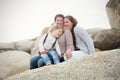 A lesbian couple with a child on the rocks at a beach