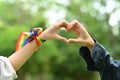 Lesbian couple making heart with their hands on blurred nature background. Support marriage equality for LGBT people Royalty Free Stock Photo