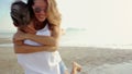 Lesbian couple run to each other and embrace on a beach