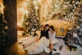 Lesbian couple hugs against background of Christmas decorations and retro car