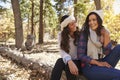 Lesbian couple sitting in a forest, looking at each other Royalty Free Stock Photo