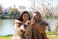 Lesbian couple sitting on a park bench. They look very much in love and happy as they are interacting with each other, talking,