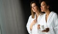 Lesbian couple relaxing and drinking tea in robes during wellness weekend Royalty Free Stock Photo