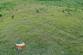 Lesbian woman with LGBT flag on green field