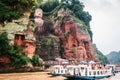 View of the Leshan Giant Buddha and tourists boats on Min river in Leshan Sichuan China