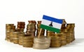 Lesotho flag with stack of money coins