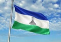 Lesotho flag waving with sky on background realistic 3d illustration