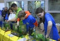 Lesson of aquarium husbandry. Girls arranging decorations in an empty aquarium