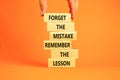 Lesson from mistake symbol. Concept words Forget the mistake remember the lesson on wooden blocks on a beautiful orange table