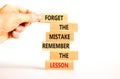 Lesson from mistake symbol. Concept words Forget the mistake remember the lesson on wooden blocks on a beautiful white table white