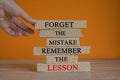 Lesson from mistake symbol. Concept words Forget the mistake remember the lesson on brick blocks on a beautiful wooden table,