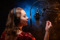 Lesson and training in vocal and singing. A girl sings into a microphone, bright background