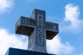 Lest we Forget stone cross memorial for world war two veterans on a blue sky cloudy background