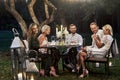 Let candles burn that night. Group of adult friends have a rest and conversation in the backyard of restaurant at Royalty Free Stock Photo