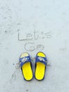 Let go word on the beach and yellow sandal Royalty Free Stock Photo