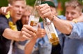 Let the good times flow. Cropped shot a group of young men toasting with beer bottles. Royalty Free Stock Photo