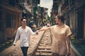 Let love lead the way. a young couple walking on the train tracks through the streets of Vietnam.