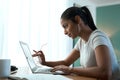 Let me have a closer look. a young woman doing paperwork while using a laptop at home. Royalty Free Stock Photo