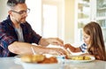 Let me help you...an adorable little girl having breakfast with her father in the kitchen. Royalty Free Stock Photo
