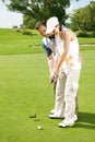 Let me help you line up your shot. Young couple playing golf together on the green.