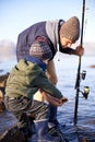 Let me see...a cute little boy fishing with his father by the sea. Royalty Free Stock Photo