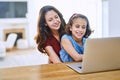 Let me show where to click. a mother and daughter using a laptop together at home.