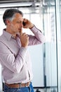 Let me think...A mature businessman looking thoughtful while talking on his phone. Royalty Free Stock Photo