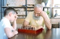 Pensive senior man and his grandson playing chess Royalty Free Stock Photo