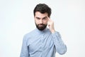 Let me think. Serious hispanic man with beard, keeps index finger on temple, recollect something in mind Royalty Free Stock Photo