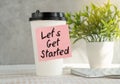 Let\'s Get Started Text Written on Sticky Paper on Coffee Gass on Office Desk