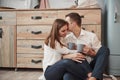 Let`s keep it secret. Husband with his wife relaxing by sitting on the kitchen and having good conversation Royalty Free Stock Photo