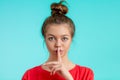 Let`s keep a secret. stylisg sporty girl showing silence gesture Royalty Free Stock Photo