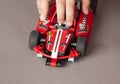 Child hand with LEGO Technic Race Car.