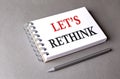 LET\'S RETHINK word on notebook on grey background Royalty Free Stock Photo