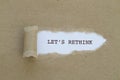 LET`S RETHINK word written under torn paper. Royalty Free Stock Photo