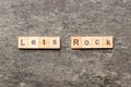 Let's Rock word written on wood block. Lets Rock text on cement table for your desing, concept Royalty Free Stock Photo